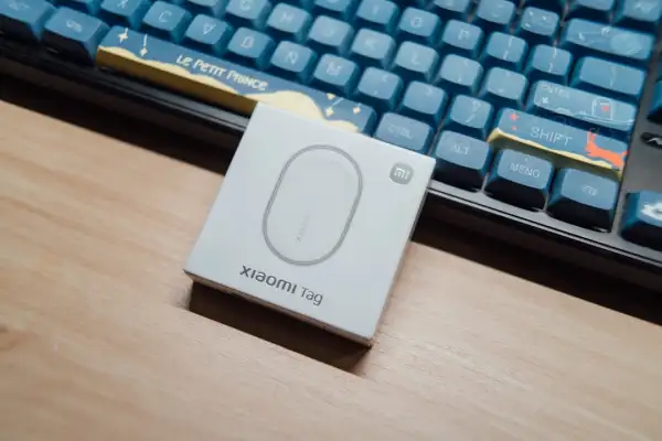 Mini traceur GPS magnétique noir posé sur une surface métallique